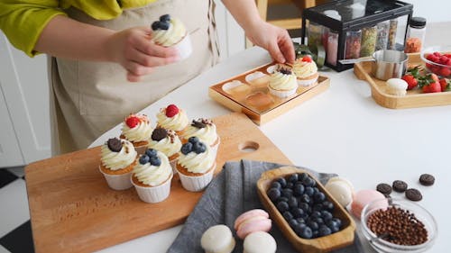 A Woman Preparing Cupcakes for Packaging