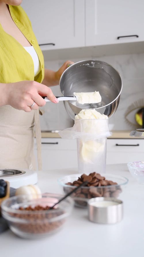 A Woman Preparing Frosting in a Piping Bag