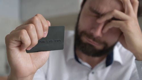 Man is Crying while Holding his Credit Card