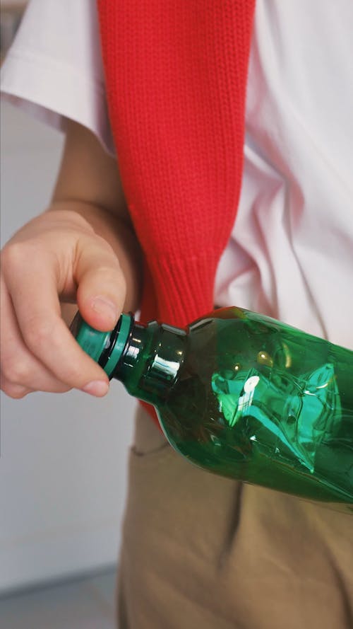 Person Removing the Cap of the Plastic Bottle