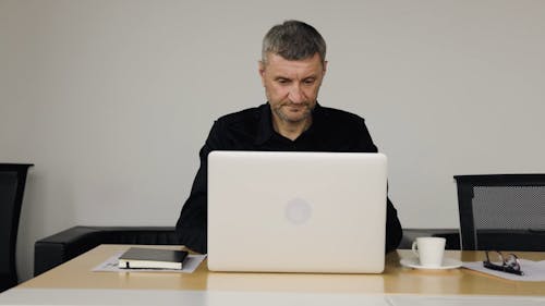 Elderly Man Typing on a Laptop