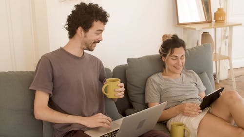 A Couple Talking while Using Their Gadgets