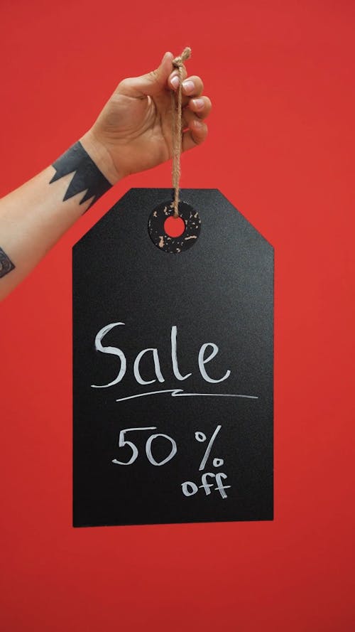 Person Holding Tag Sale Signage