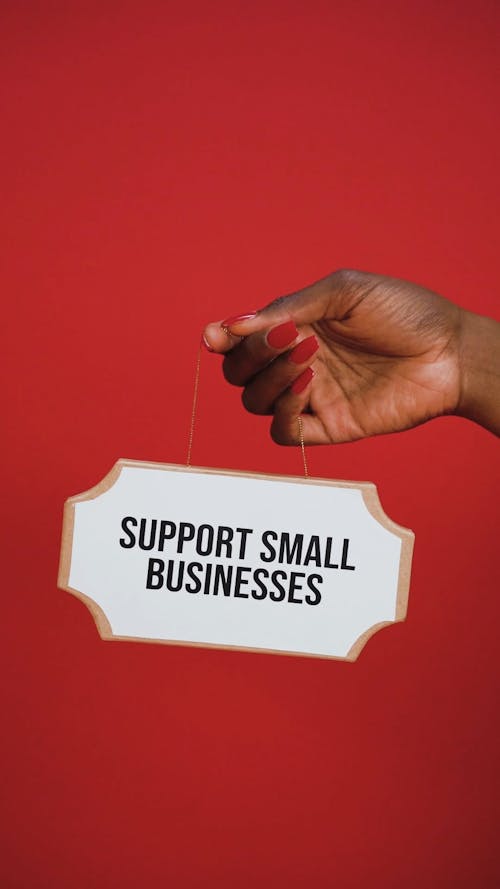 Person Holding Cardboard with a Message of Support Small Businesses