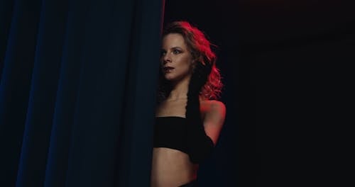 Woman Posing Seductively behind a Curtain