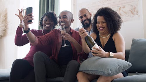 Friends Taking a Group Selfie and Popping Champagne