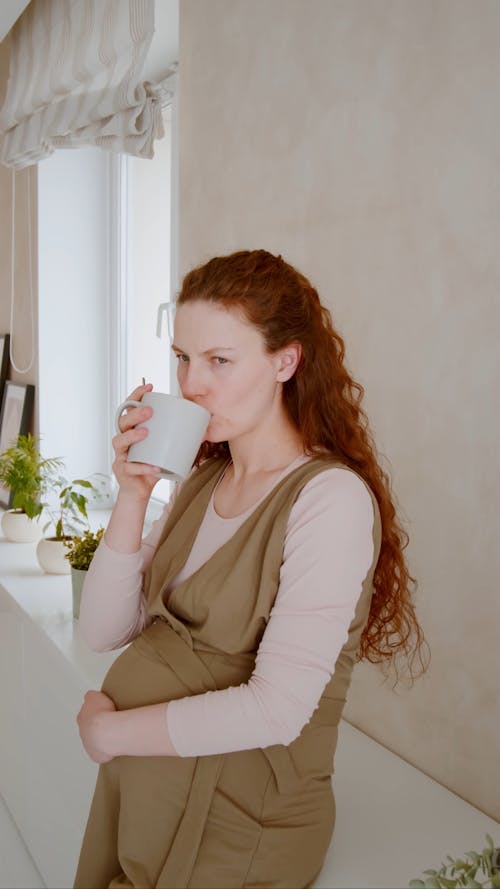 Pregnant Woman Drinking from a Cup