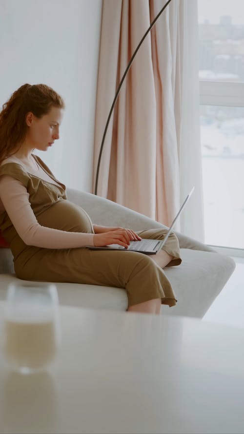 Pregnant Woman Typing on Laptop