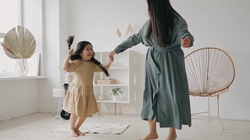 A Girl With Her Mother Jumping Happily
