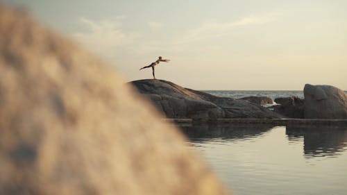 Woman Doing Yoga Over A Rock