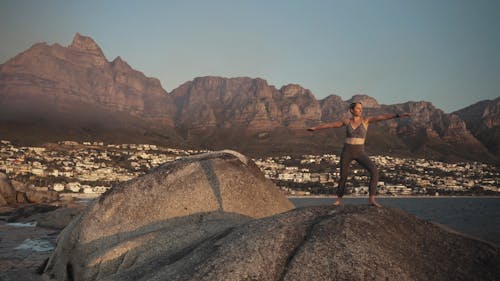 Woman Doing Yoga Over A Rock