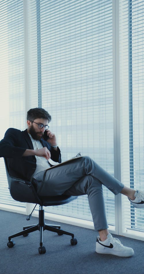 Bearded Man Talking on the Phone While Looking at the Analysis