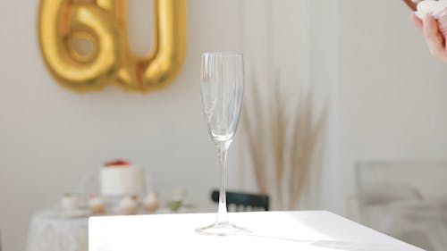 Person Pouring Champagne in a Glass