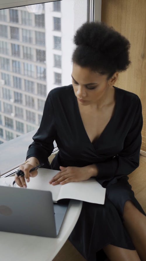 Woman Sitting Beside the Window Doing Online Class