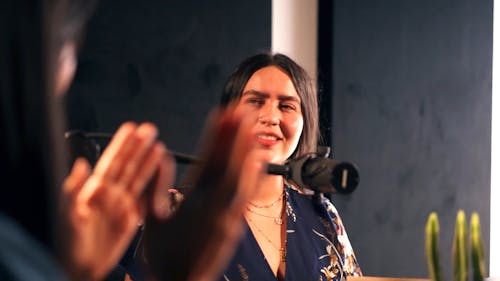 A Woman Talking in Front of a Microphone