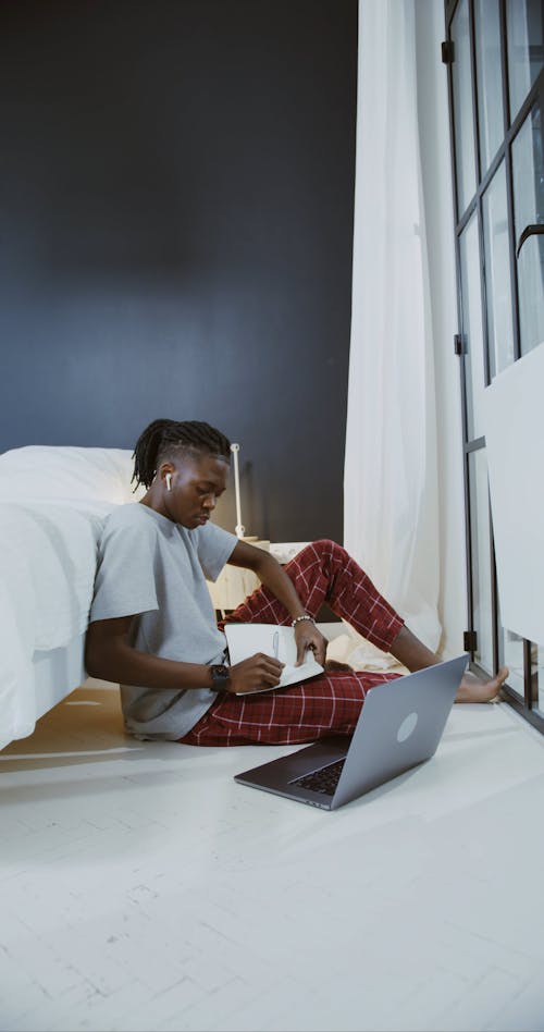 Man Writing Notes on his Notebook