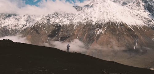 Person Standing in Front of Majestic Mountains