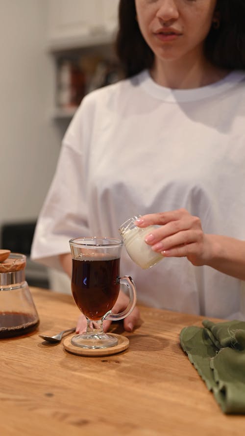 Woman Mixing Milk with Coffee