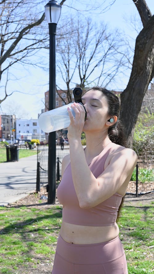 Tired Woman Drinking Water at the Park