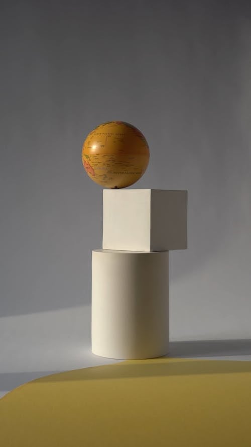 A Globe Spinning Over A Square Box