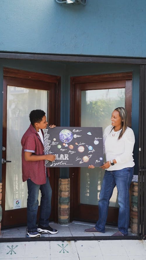 A Boy Explaining His Artwork to His Mother