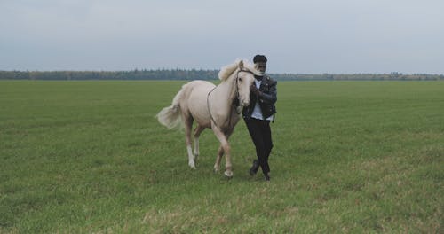 A Man Walking with a Horse in a Farm