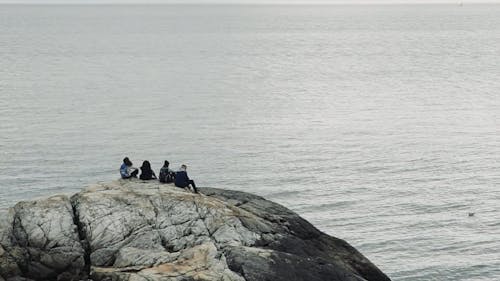 People Sitting and Relaxing on a Cliff