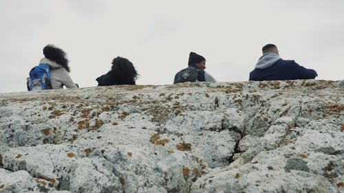 People Sitting and Relaxing on a Cliff