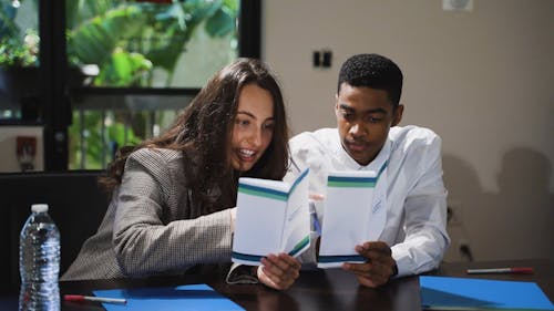 Close up Shot of Two People Reading a Brochure