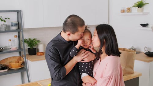 Parents Kissing Their Baby