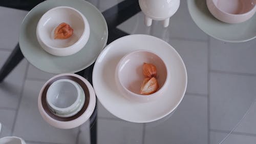 Ceramic Plates and Bowl on the Glass Table 