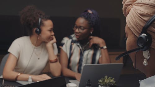 A Call Center Representative Working while Her Colleagues is Chatting