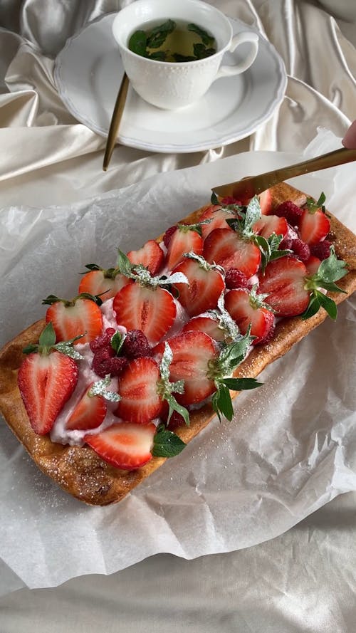 Person Slicing a Strawberry Pei