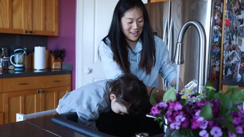 A Mother and Child Washing the Dishes