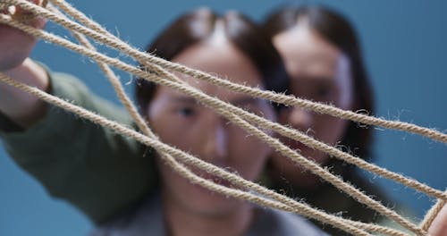 Men Looking at The Rope They're Holding