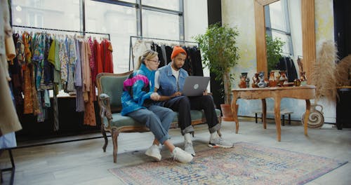 Man and Woman Using Laptop while in the Boutique