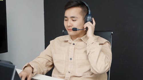 Call Center Agent Talking using Headphones while using Laptop