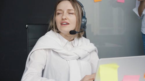 A Woman Using a Headset and Taking Notes