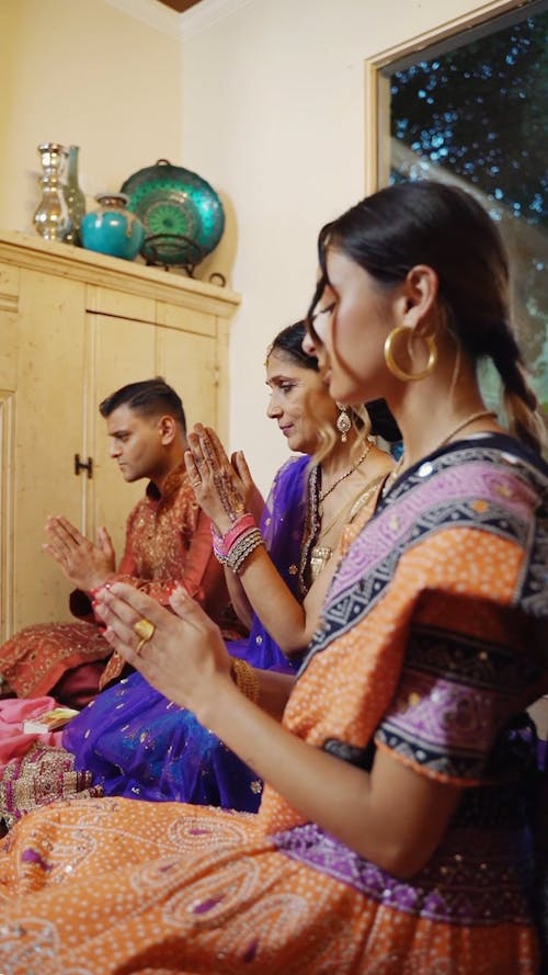 A Family in Traditional Clothing Praying at Home
