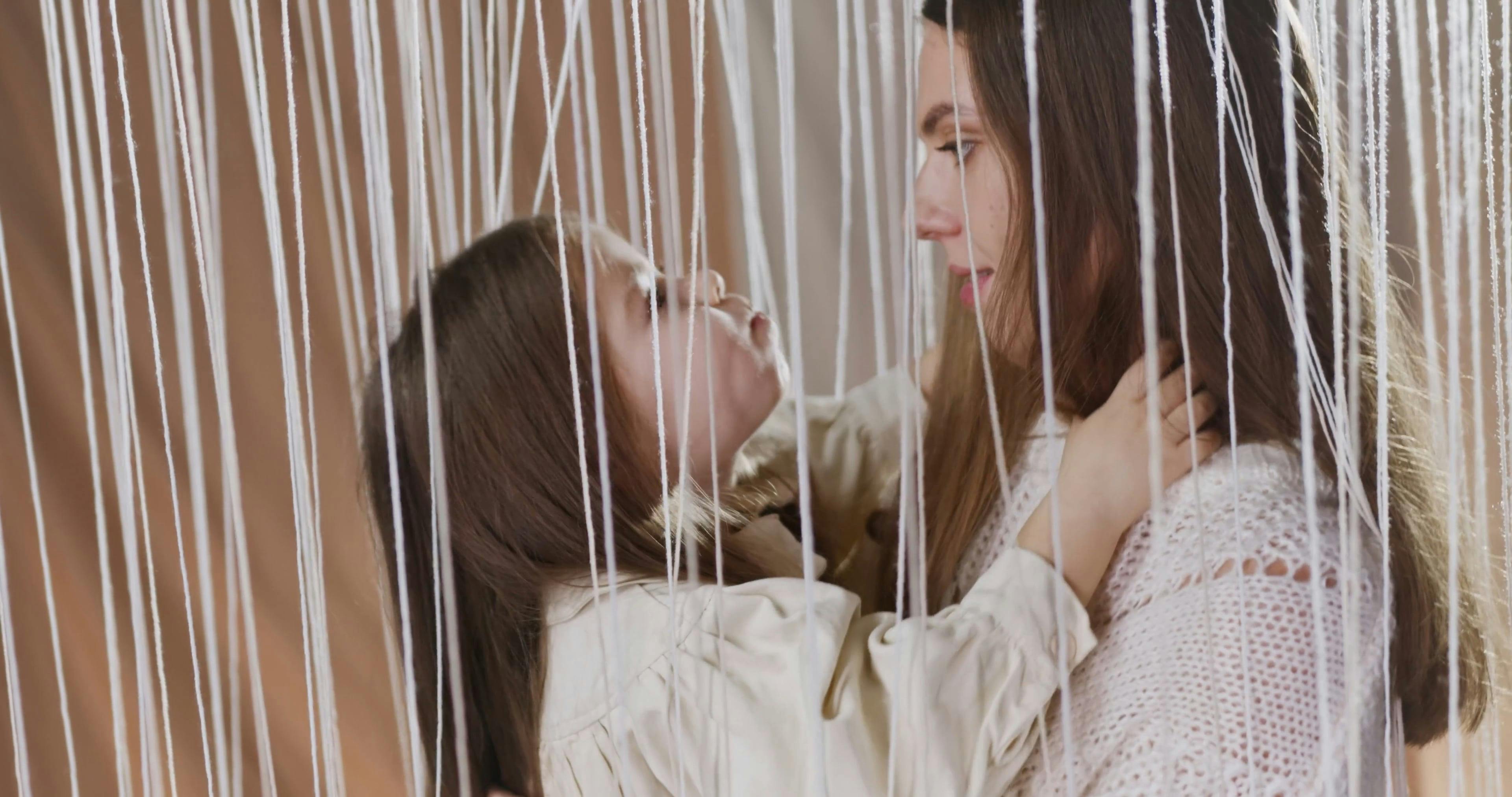 Mother and Daughter Posing Behind Strings · Free Stock Video