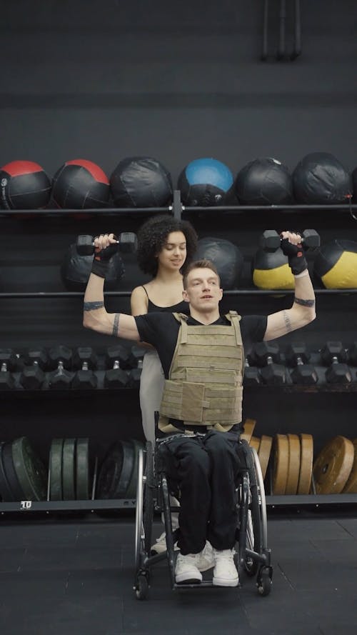 Man in Wheelchair Lifting Weights with Trainer