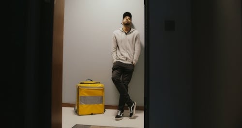 A Delivery Man Standing Beside a Thermal Bag