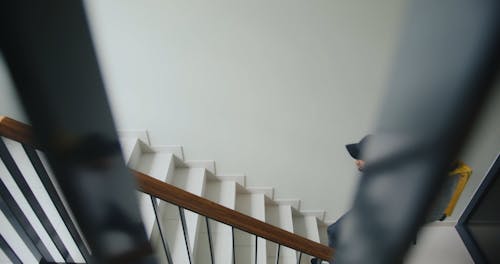 A Delivery Man Going Up the Stair while Carrying a Thermal Bag