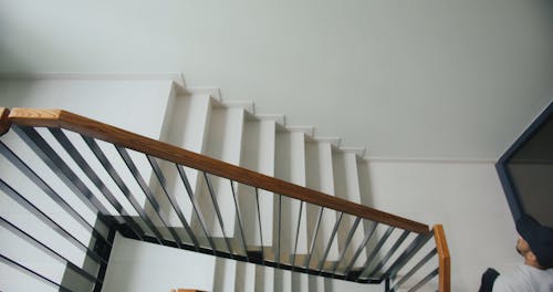 A Delivery Man Going Up the Stair while Carrying a Thermal Bag