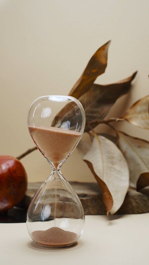 An Hourglass and a Pomegranate on a Stone Slab