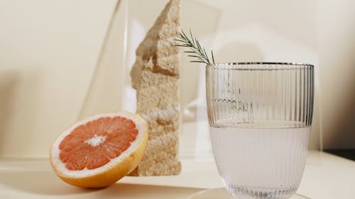 Glass of Water Beside a Grapefruit