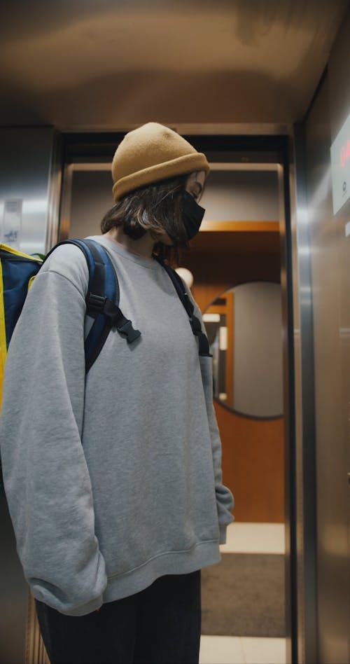 A Delivery Woman Riding an Elevator