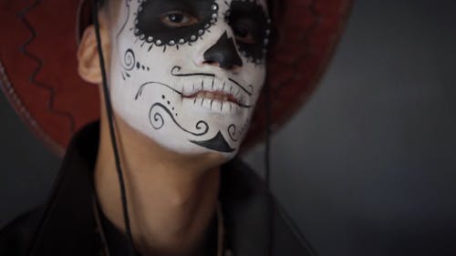 A Man with a Muertos Face Painting