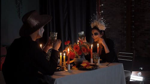 A Couple with a Muertos Face Painting Having a Date