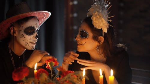 A Couple with a Muertos Face Painting Having a Date